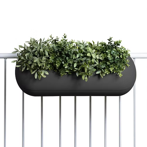 Ein moderner schwarzer Balkonpflanzkasten, gefüllt mit üppigen grünen Pflanzen, ist an einem Geländer befestigt und bereichert den Außenbereich mit Grün.